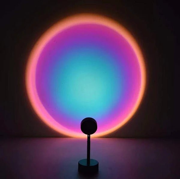 Sunset lamp projecting a vibrant multicolor gradient circle with blue, purple, and pink tones, creating a dreamy ambient lighting effect in a dark room.