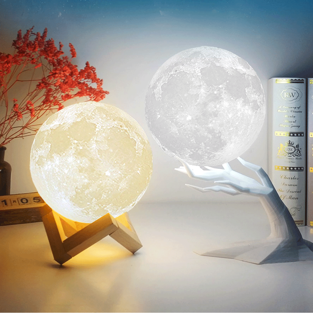 Two realistic moon lamps emitting warm yellow and cool white light, displayed on wooden and metal stands as decorative night lights.